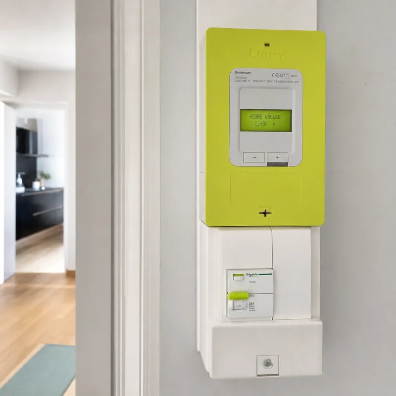 Compteur Linky fixé au mur d’un couloir d’appartement