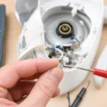 Fusible thermique cylindrique tenu entre les doigts près d’un multimètre