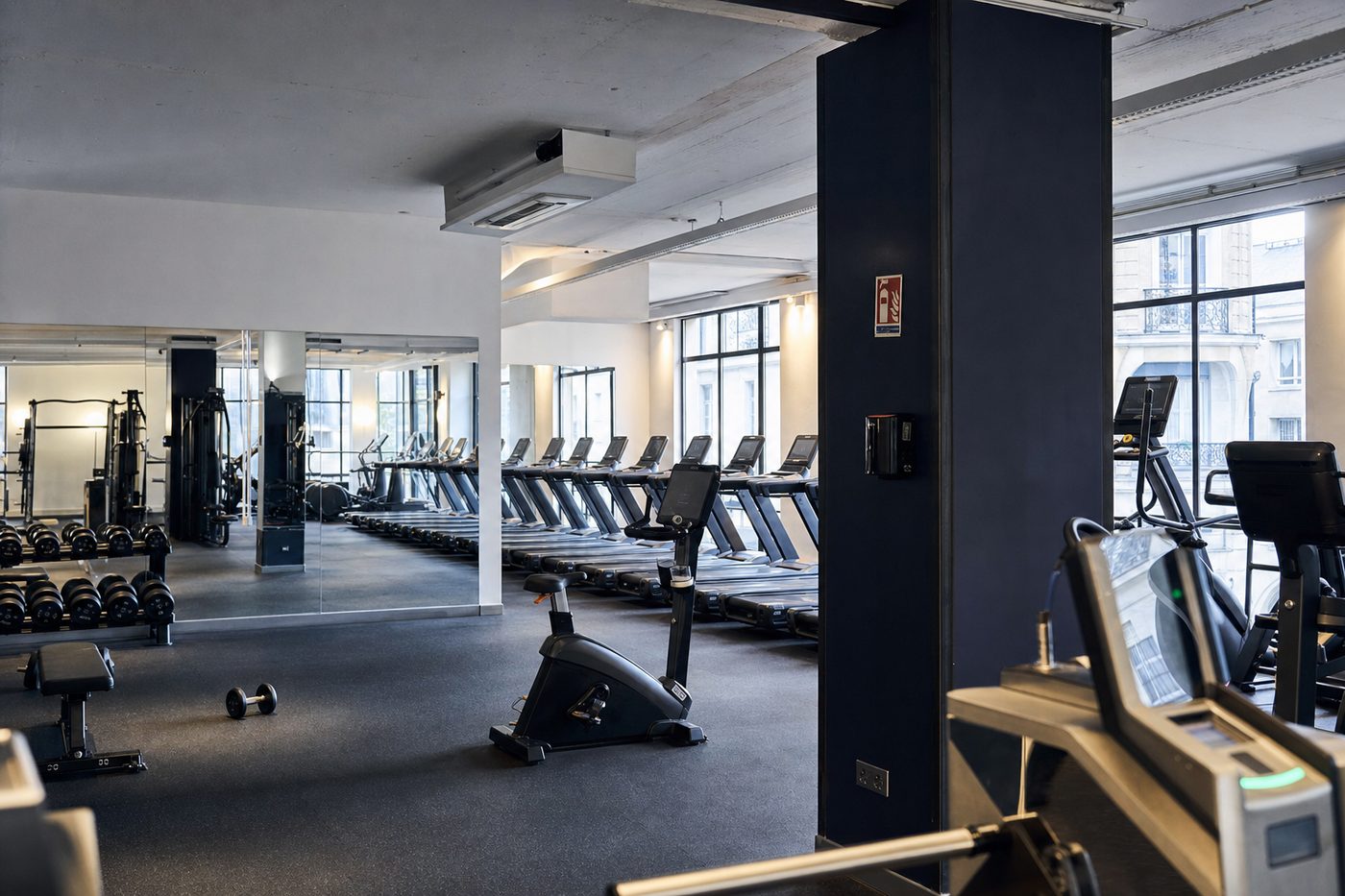 Plateau d'une salle de sport sans personnel : rangées de tapis de course, vélos et haltères
