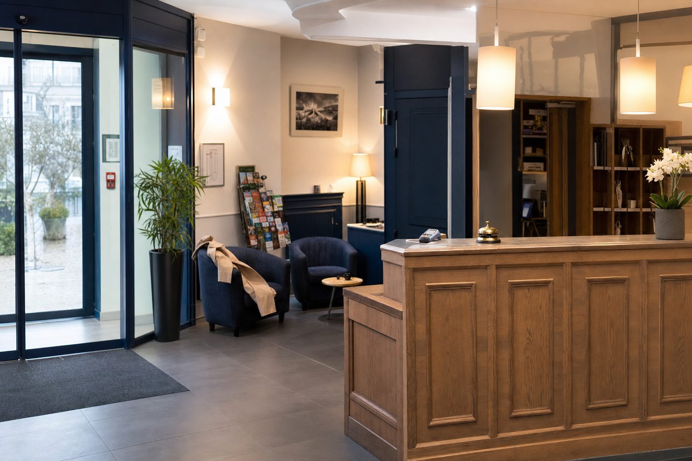 Espace d'accueil d'une résidence hôtelière : comptoir en bois, fauteuils et entrée vitrée